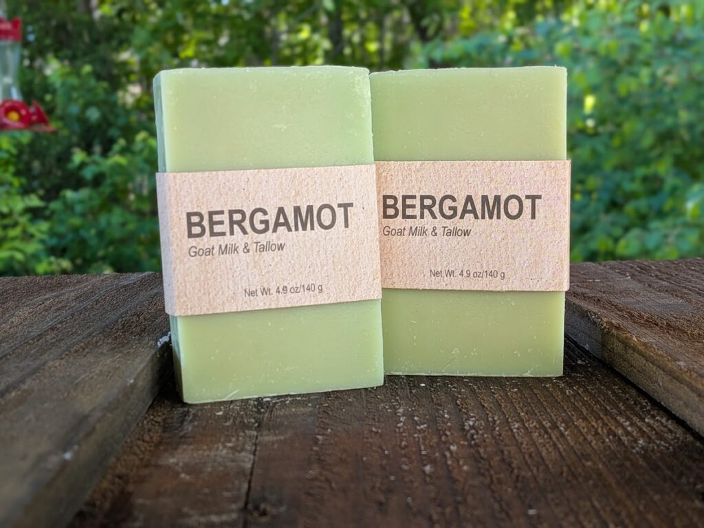 Two bars of bergamot-scented soap standing on end next to each other.